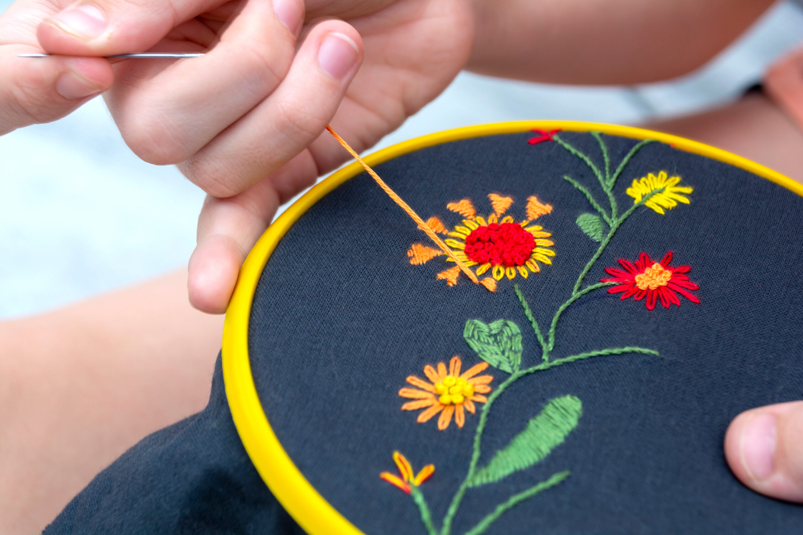 Women's hand embroideryof colorful flowers in a hoop