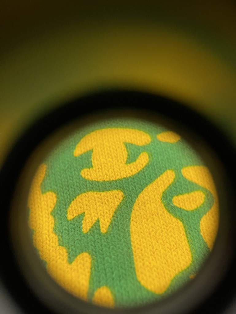 Zoomed in view of water based screen printing on fabric from a loupe